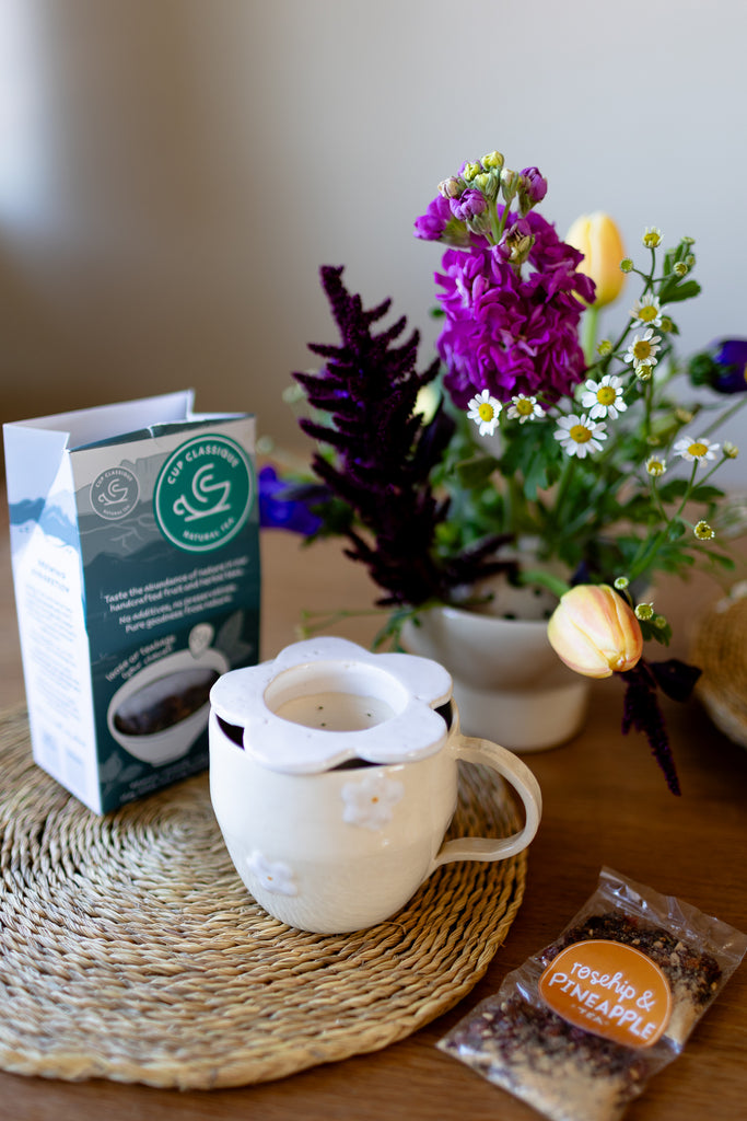 Handmade white ceramic tea strainer with floral cut-out design for loose leaf tea.