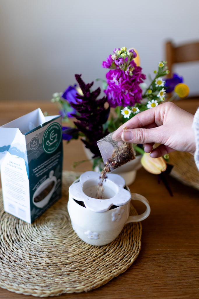 Handmade white ceramic tea strainer with floral cut-out design for loose leaf tea.