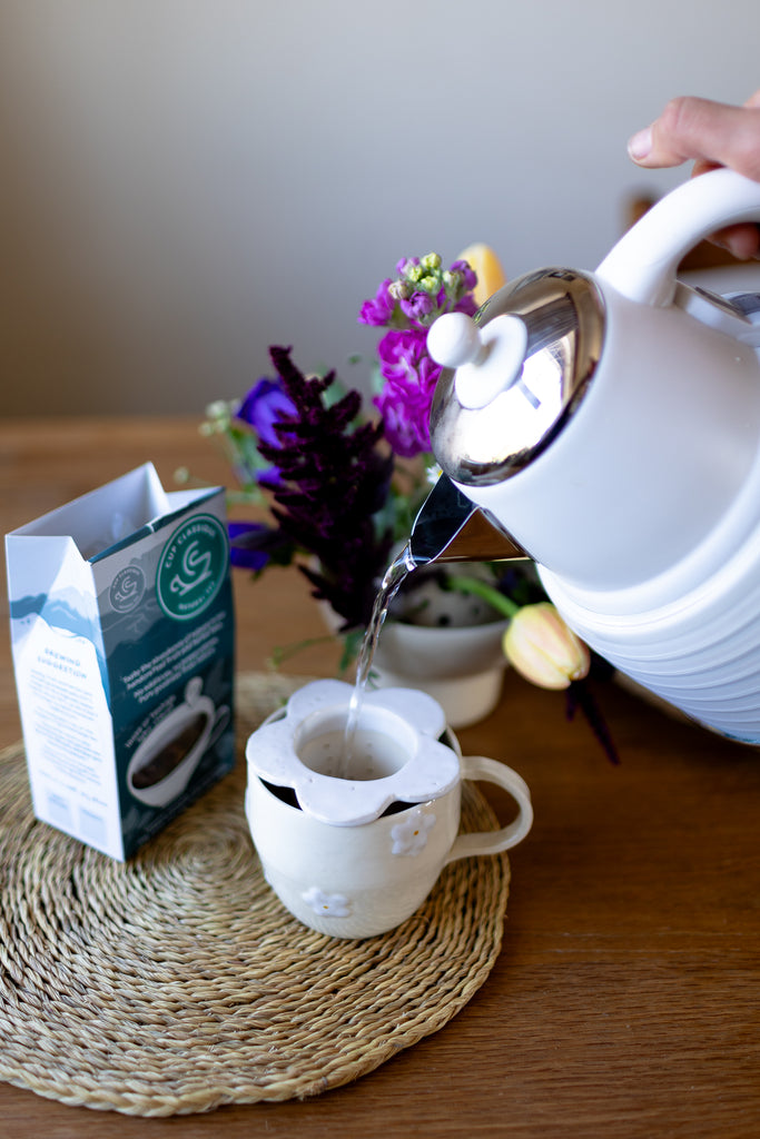 Handmade white ceramic tea strainer with floral cut-out design for loose leaf tea.