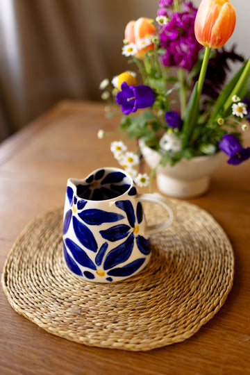 Handmade ceramic jug with blue daisy pattern, perfect as a milk jug or small vase.