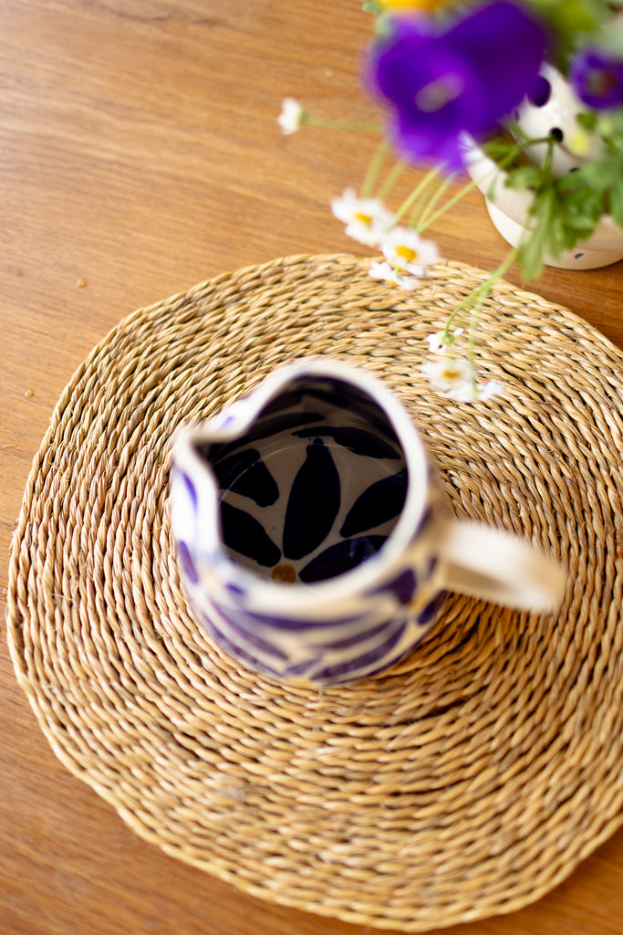 Handmade ceramic jug with blue daisy pattern, perfect as a milk jug or small vase.