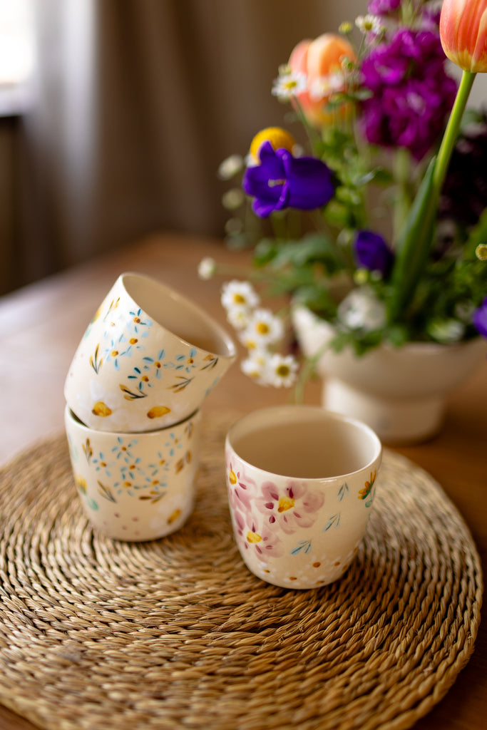 Small handmade espresso mugs with hand-painted botanical designs.