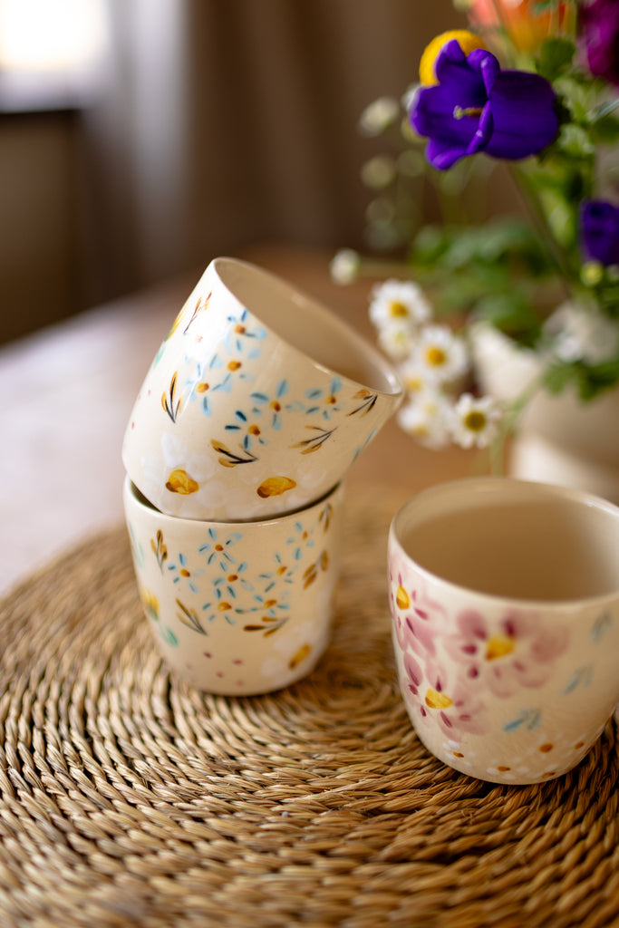 Small handmade espresso mugs with hand-painted botanical designs.