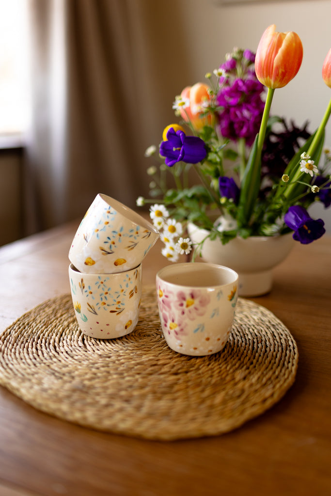 Small handmade espresso mugs with hand-painted botanical designs.