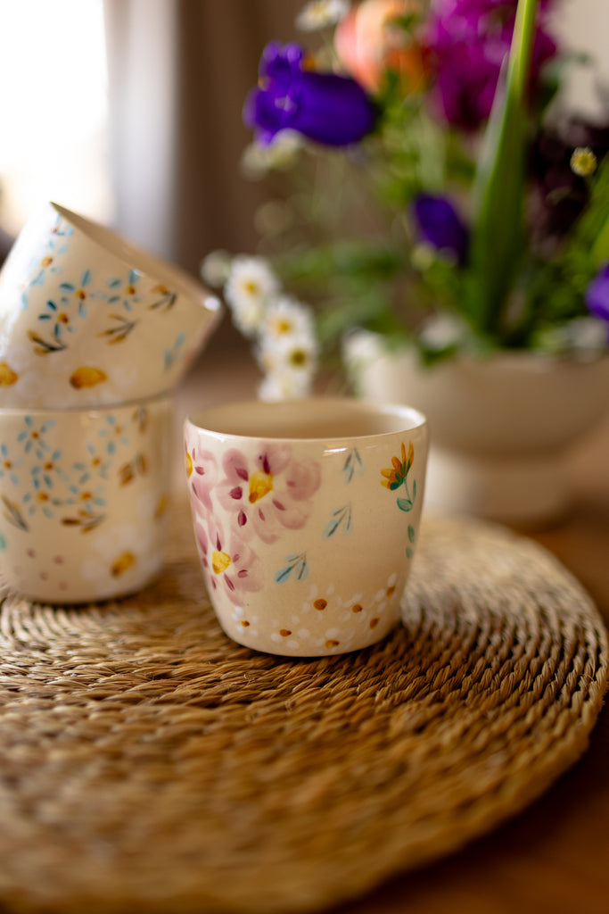 Small handmade espresso mugs with hand-painted botanical designs.