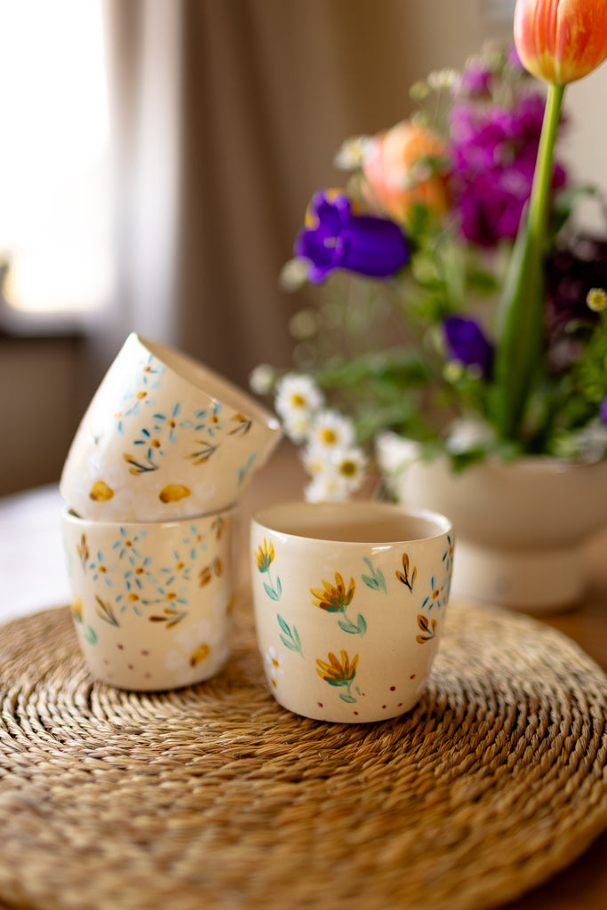Small handmade espresso mugs with hand-painted botanical designs.