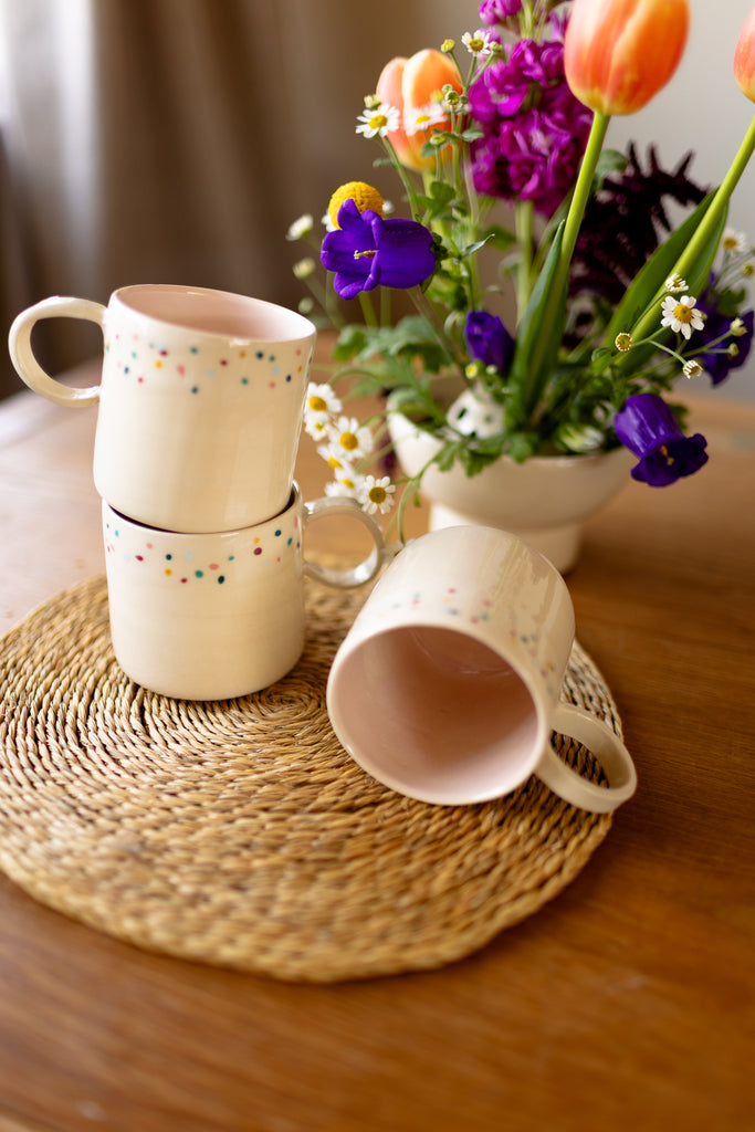 Speckled ceramic mug with round handle and glossy pink interior, 10x9cm.